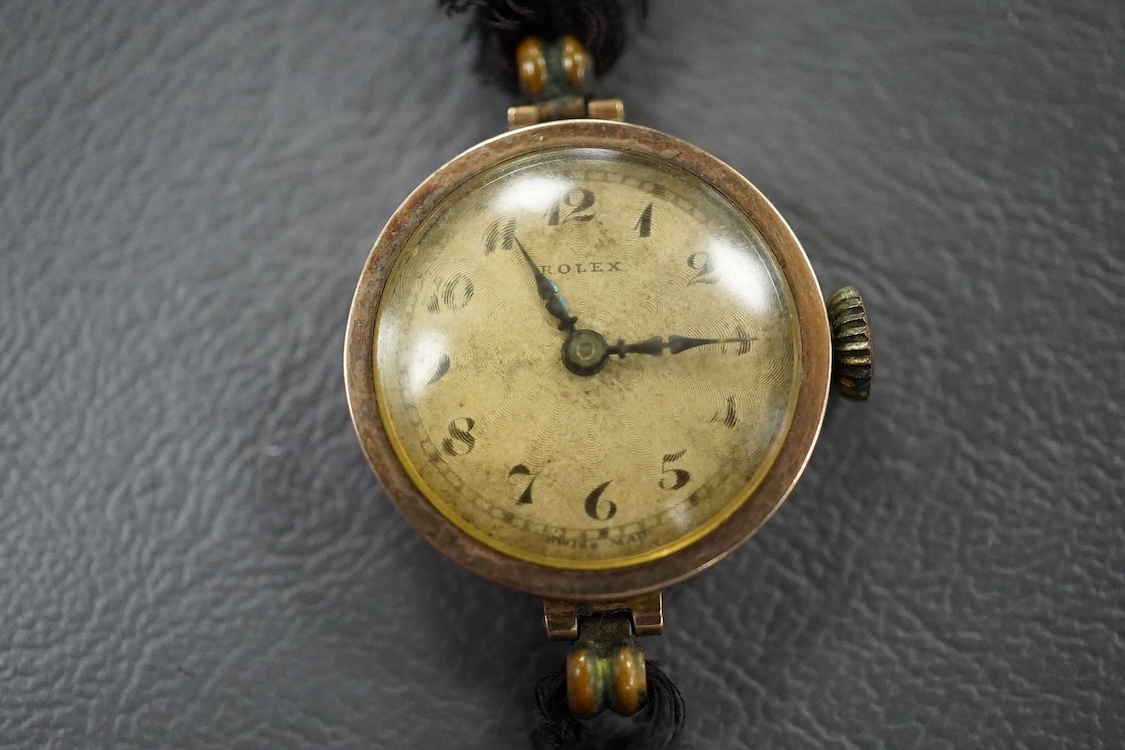 A lady's 1920's 9ct gold manual wind wrist watch, sunburst Arabic dial, case diameter 23mm, on and associated fabric strap.